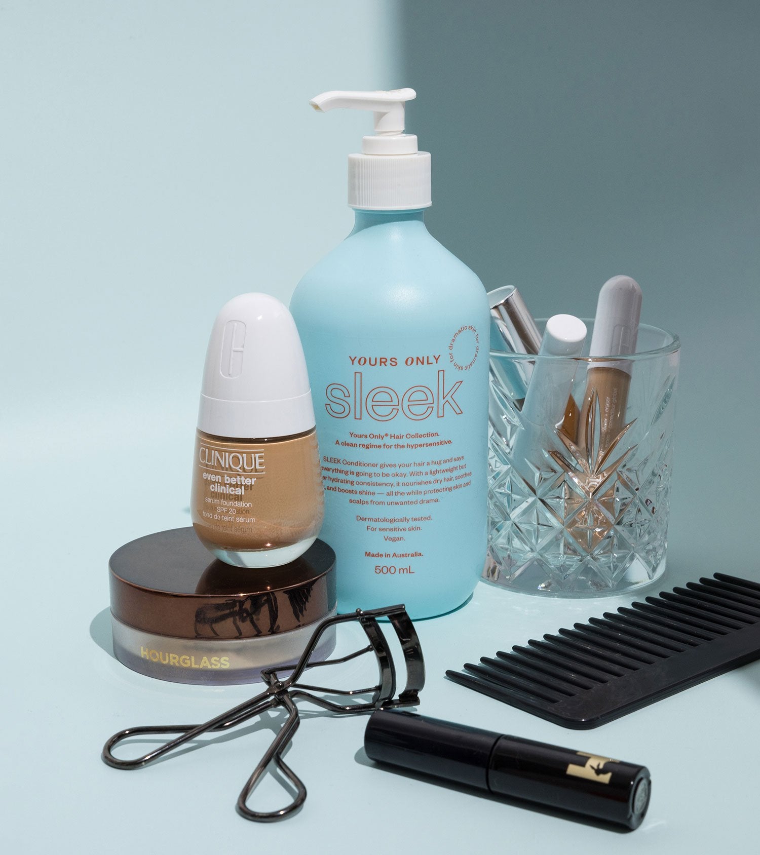 Sleek hair conditioner 500mL, Clinique foundation, Hourglass powder, eyelash curler, mascara, comb, and glass