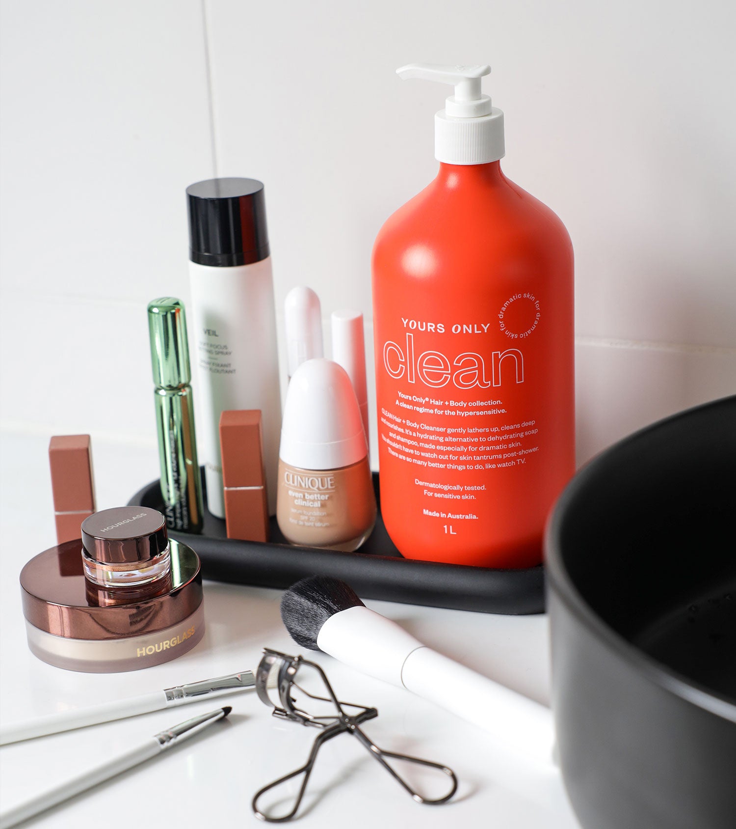 Yours Only Clean 1L bottle and other beauty products on a black tray