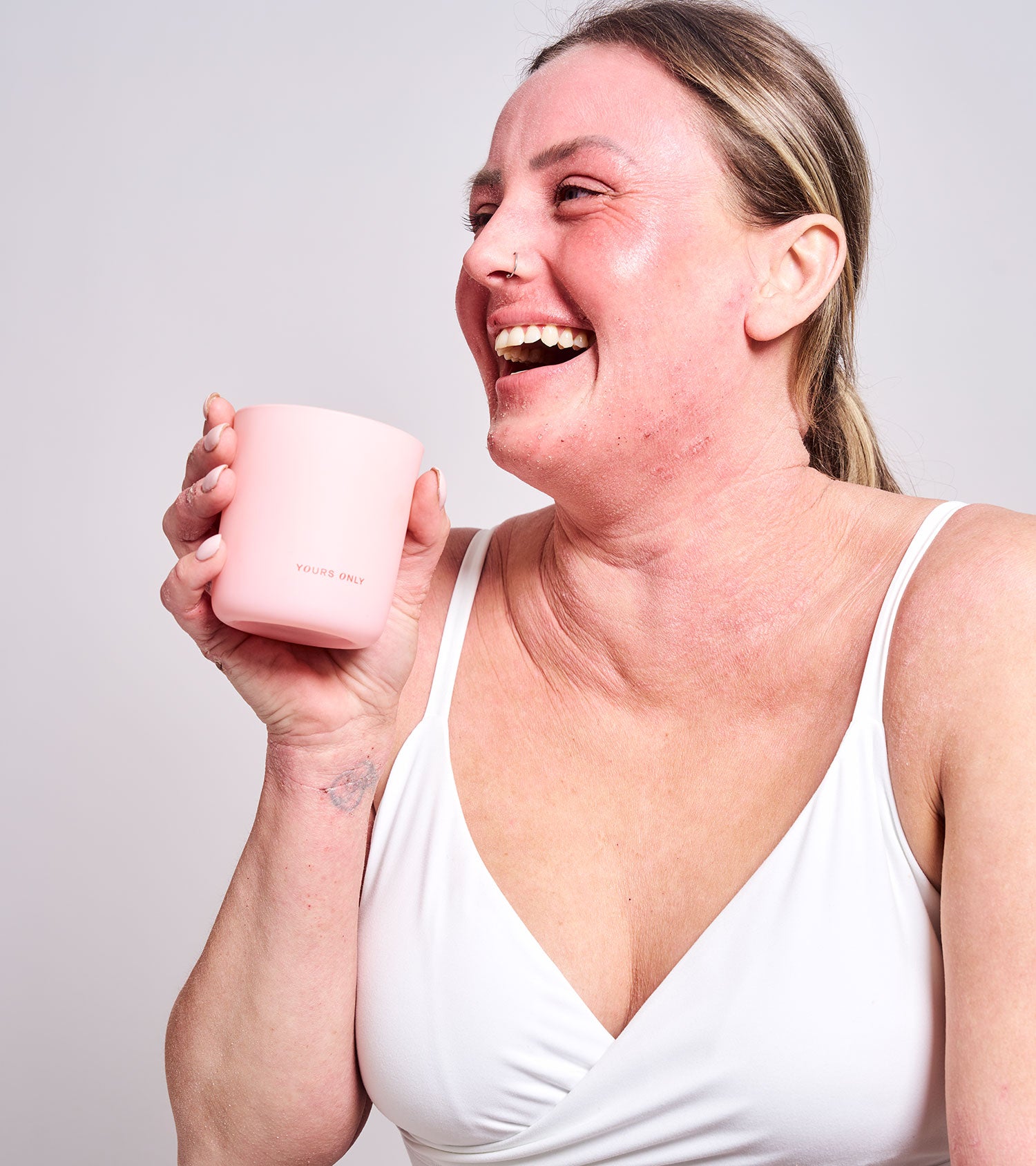 Woman with red skin holding a pink candle
