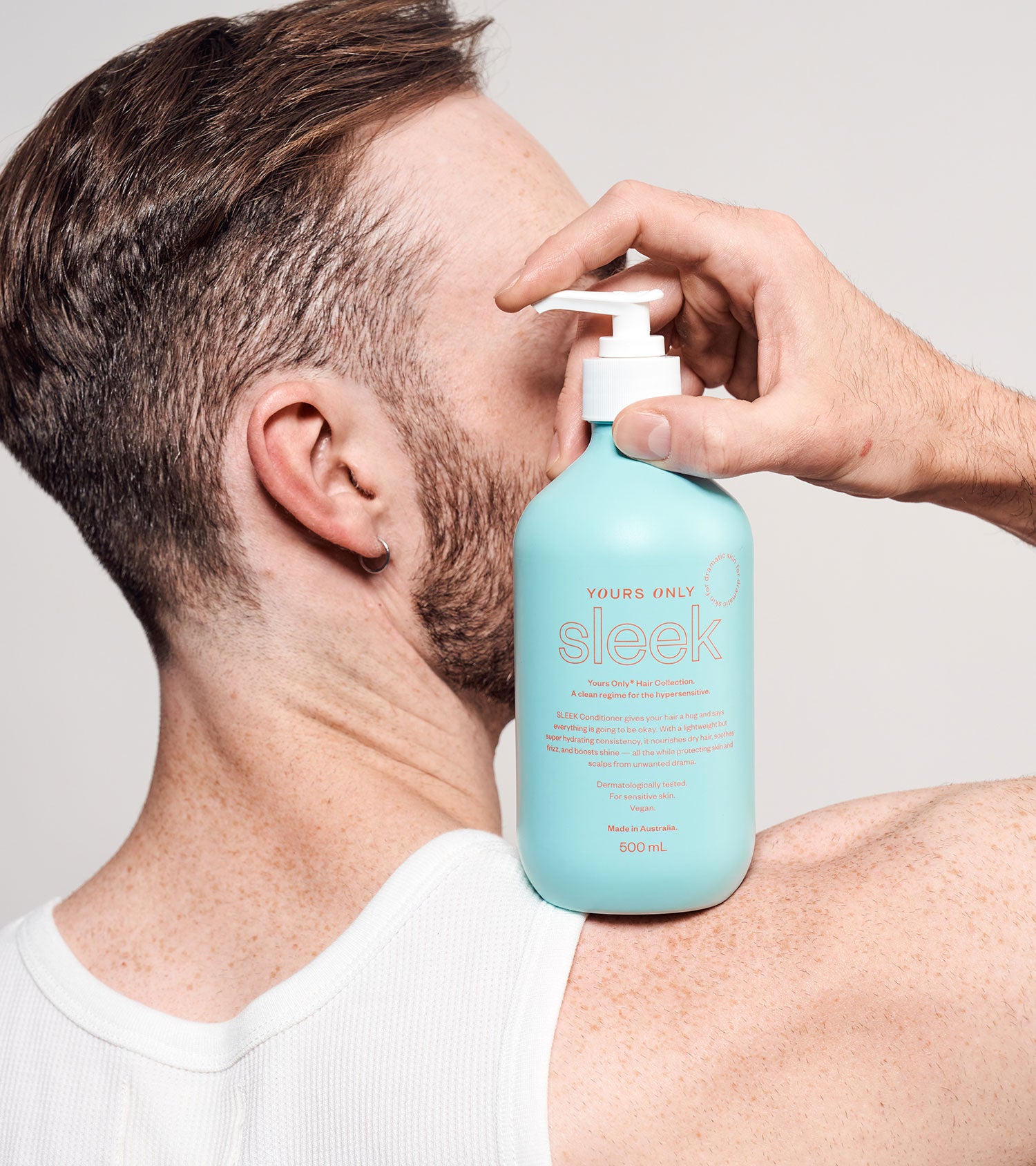 Man holding a 500mL bottle of Sleek Hair Conditioner