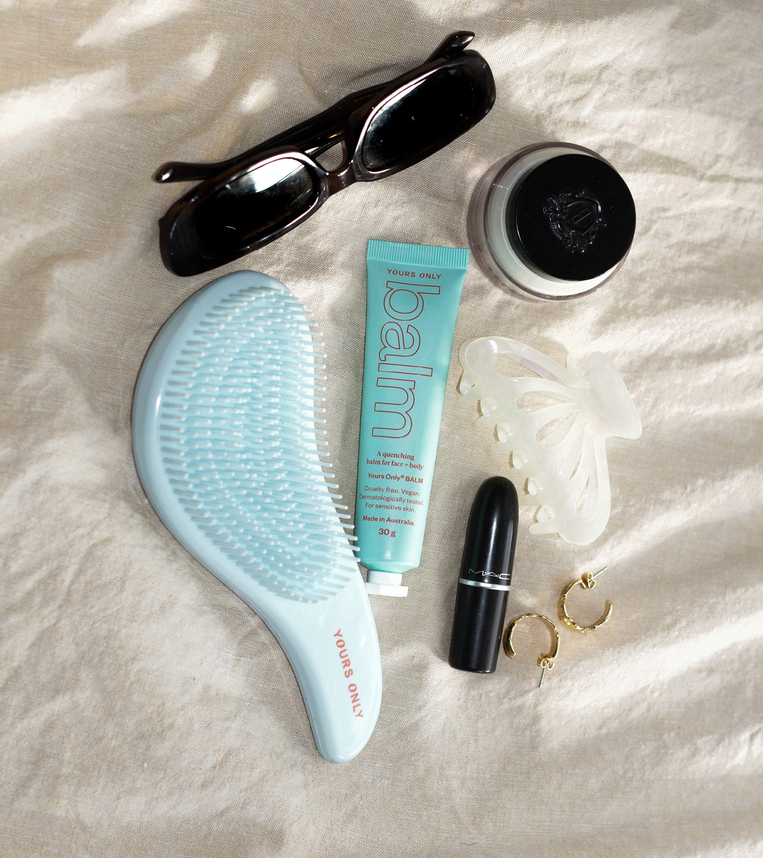 Lip + body balm 30g with sunglasses, hairbrush, hair clip, lipstick, and earrings