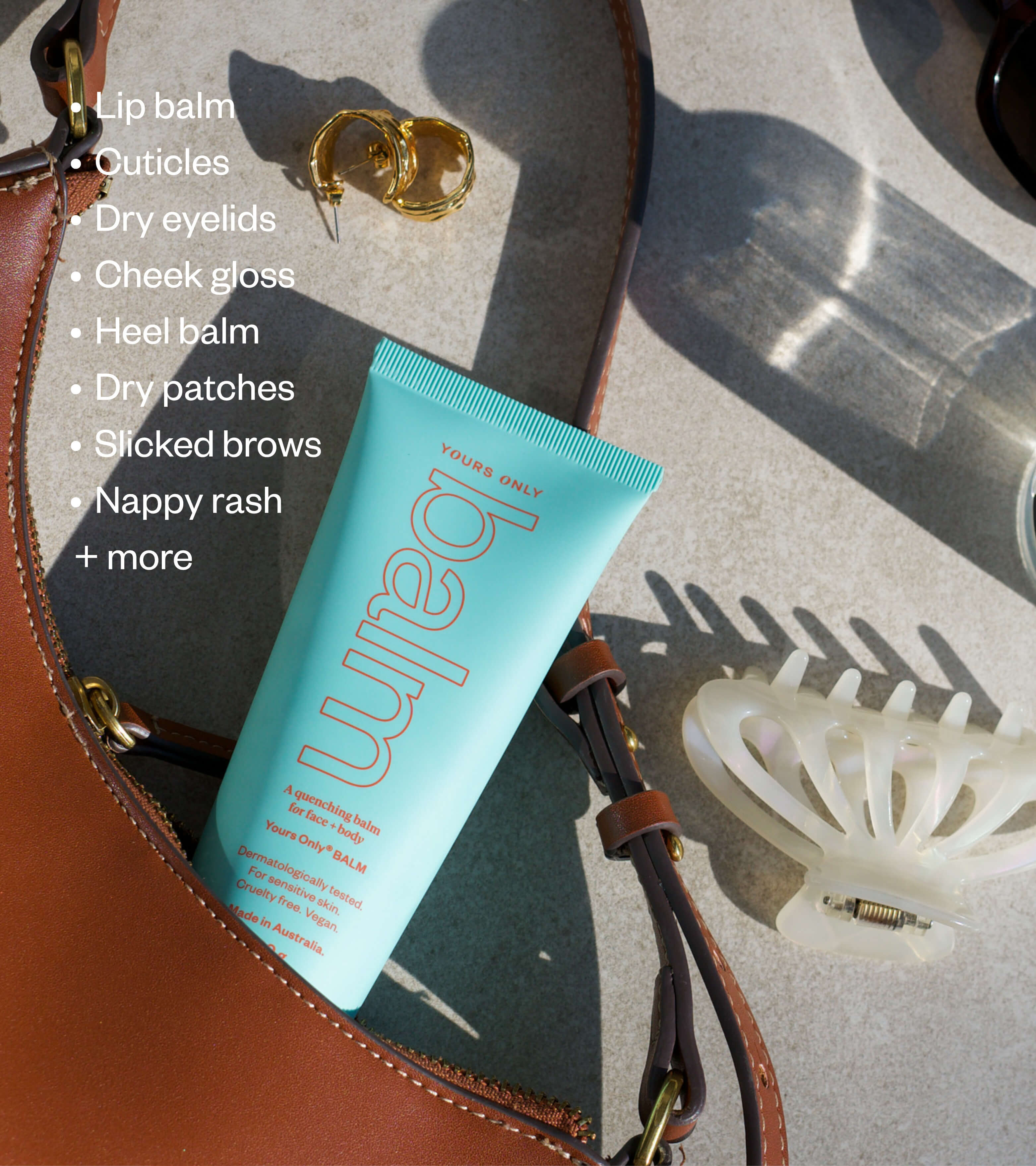 Lip + body balm 100g GWP in a turquoise tube, next to a brown bag and gold earrings