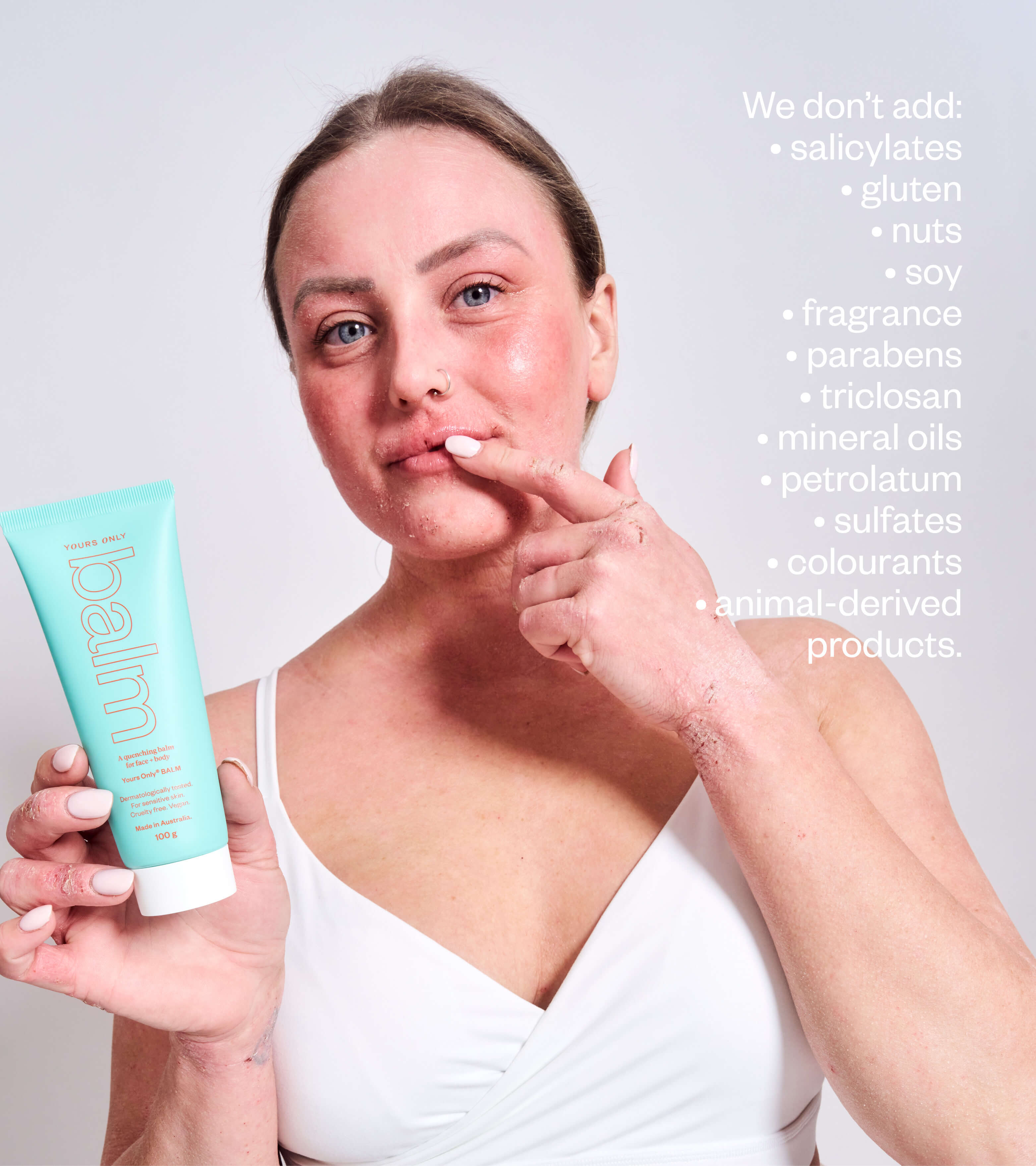 Woman with sensitive skin holding Yours Only lip + body balm 100g