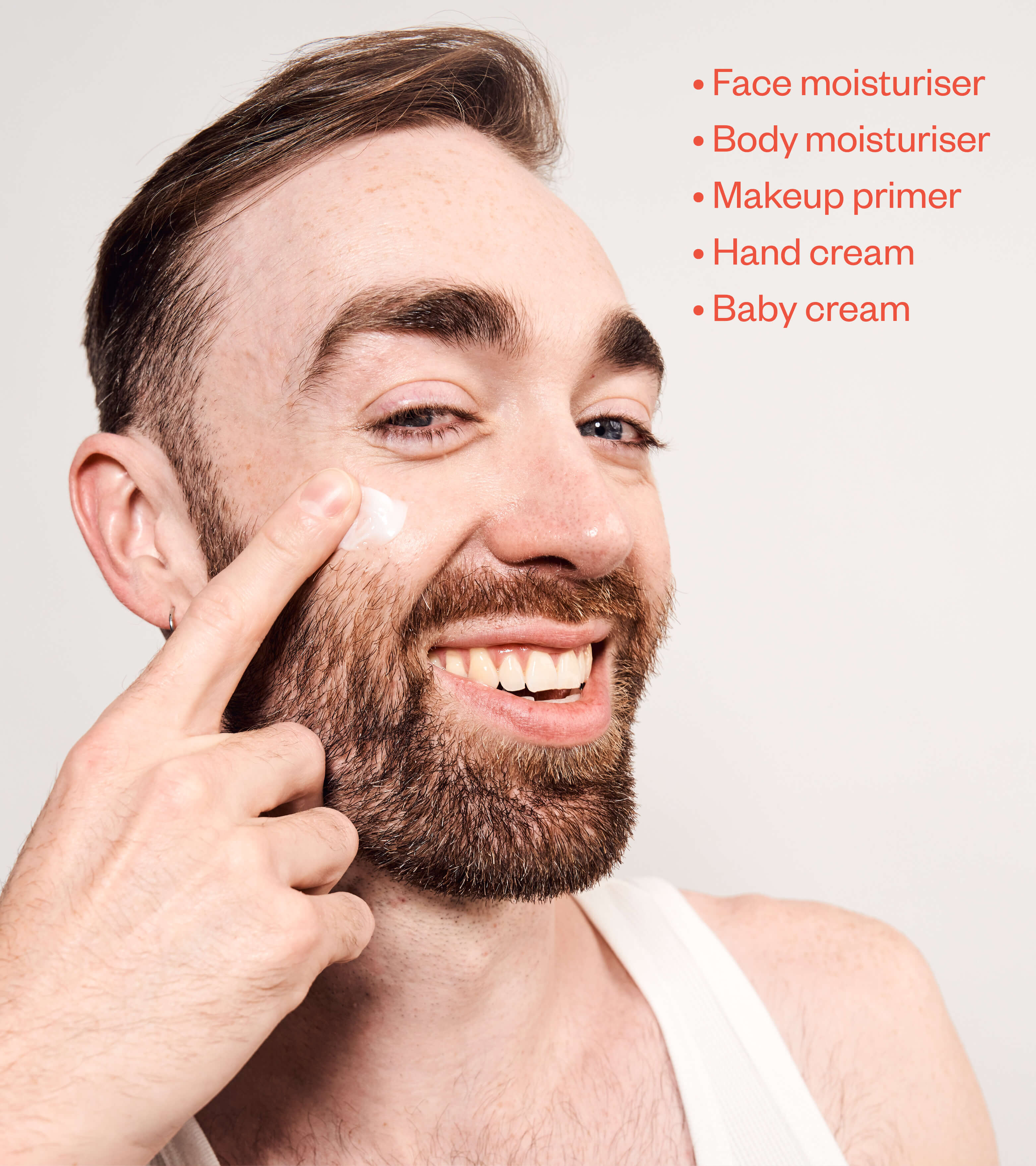 Man applying Coat moisturiser to his cheek, with a list of uses: face, body, makeup primer, hand, baby cream