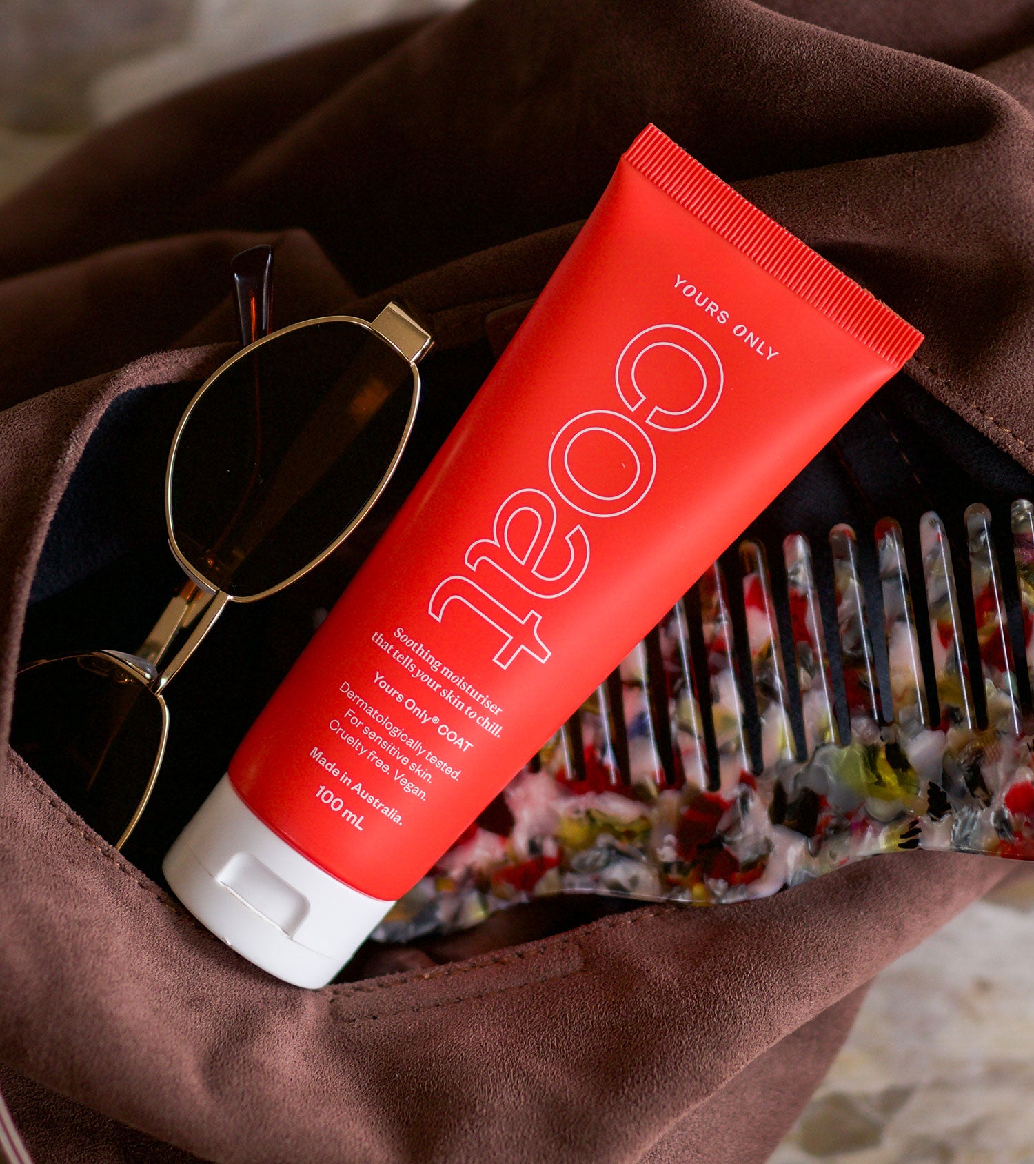 2 x coat 100mL tube, sunglasses, and a comb in a brown bag