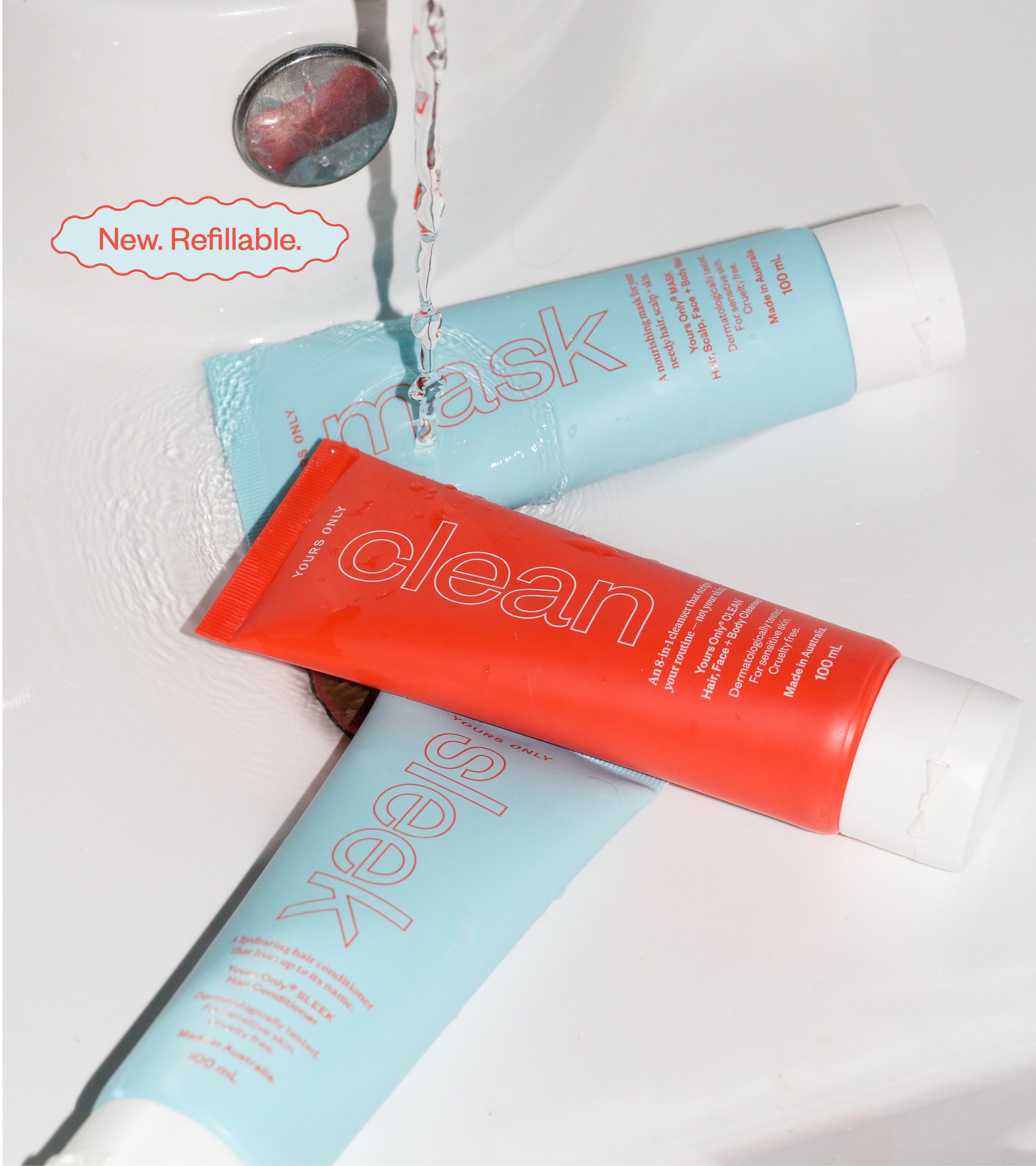 Hair 100mL bundle with three tubes: Mask, Clean, and Sleek. Water runs over the tubes in a sink