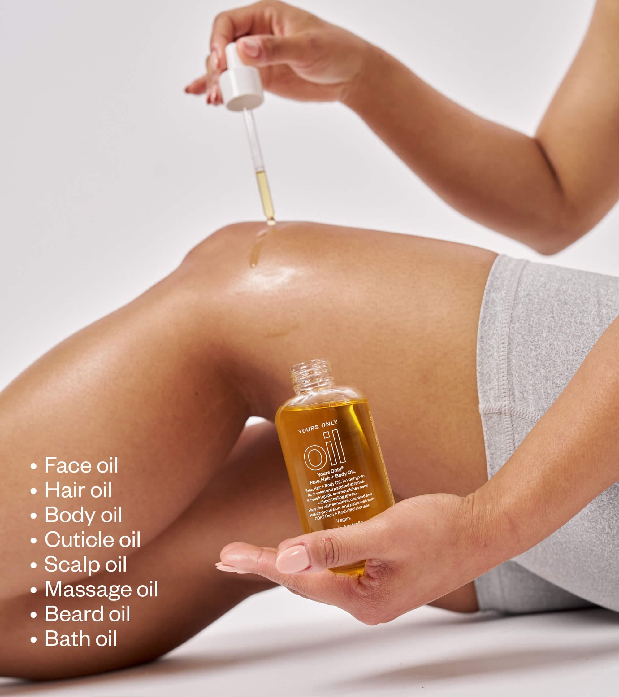 Woman applying 2 x OIL 125mL to her leg, with a list of uses next to her