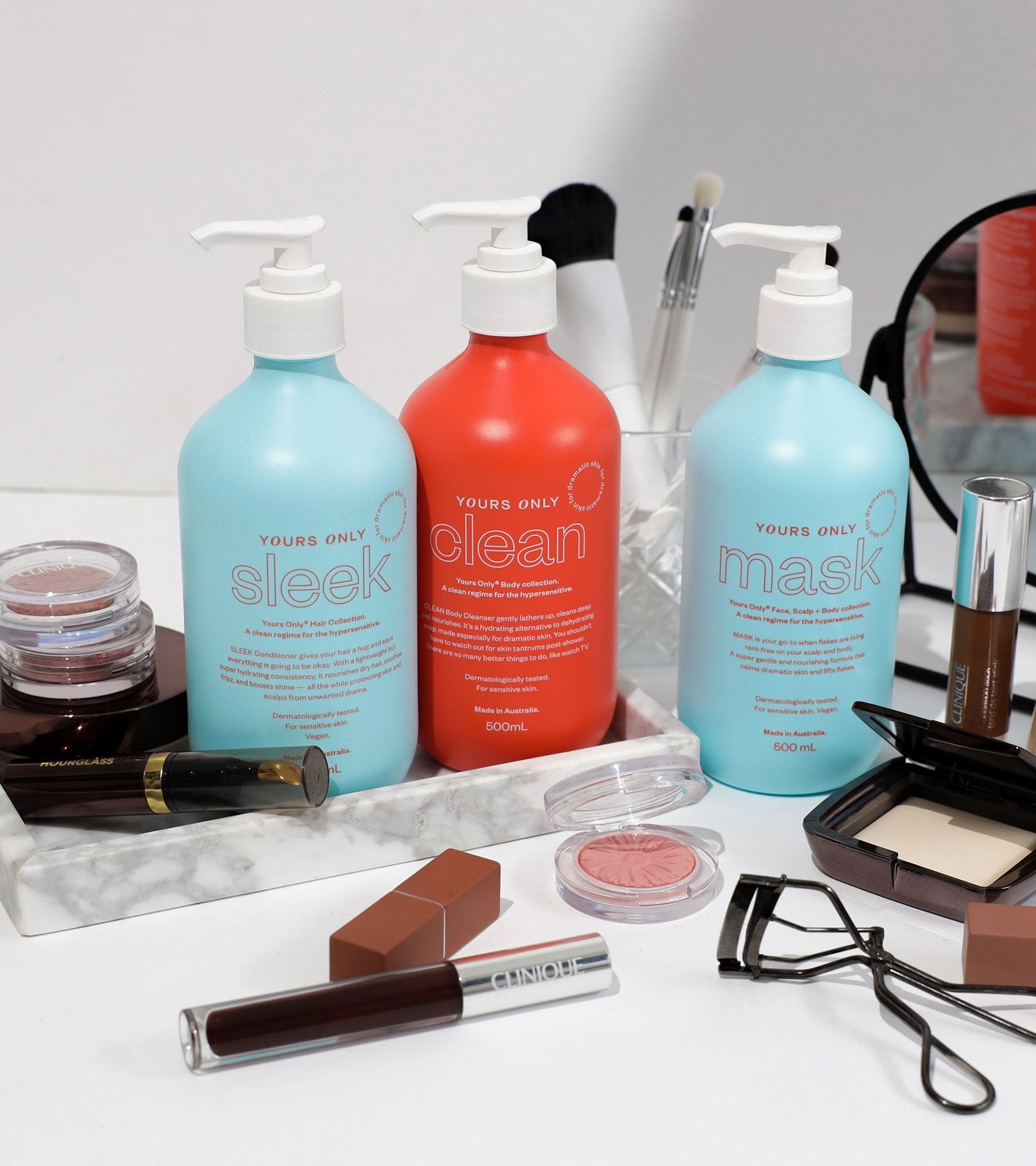 Pre-order hair bundle with three bottles of Yours Only hair products and makeup on a marble tray