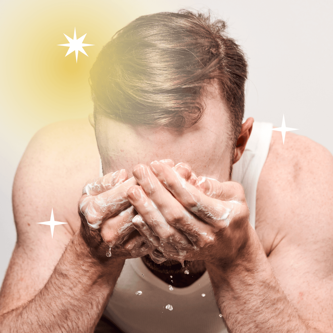Man washing his face with foamy cleanser, water dripping from his hands