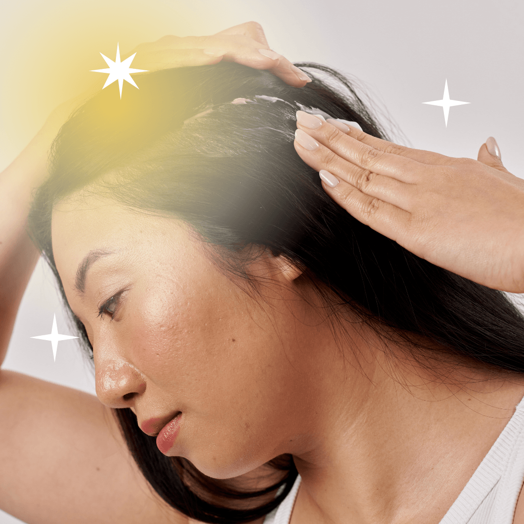 Woman applying product to her dark hair, with a glowing effect and stars around her head