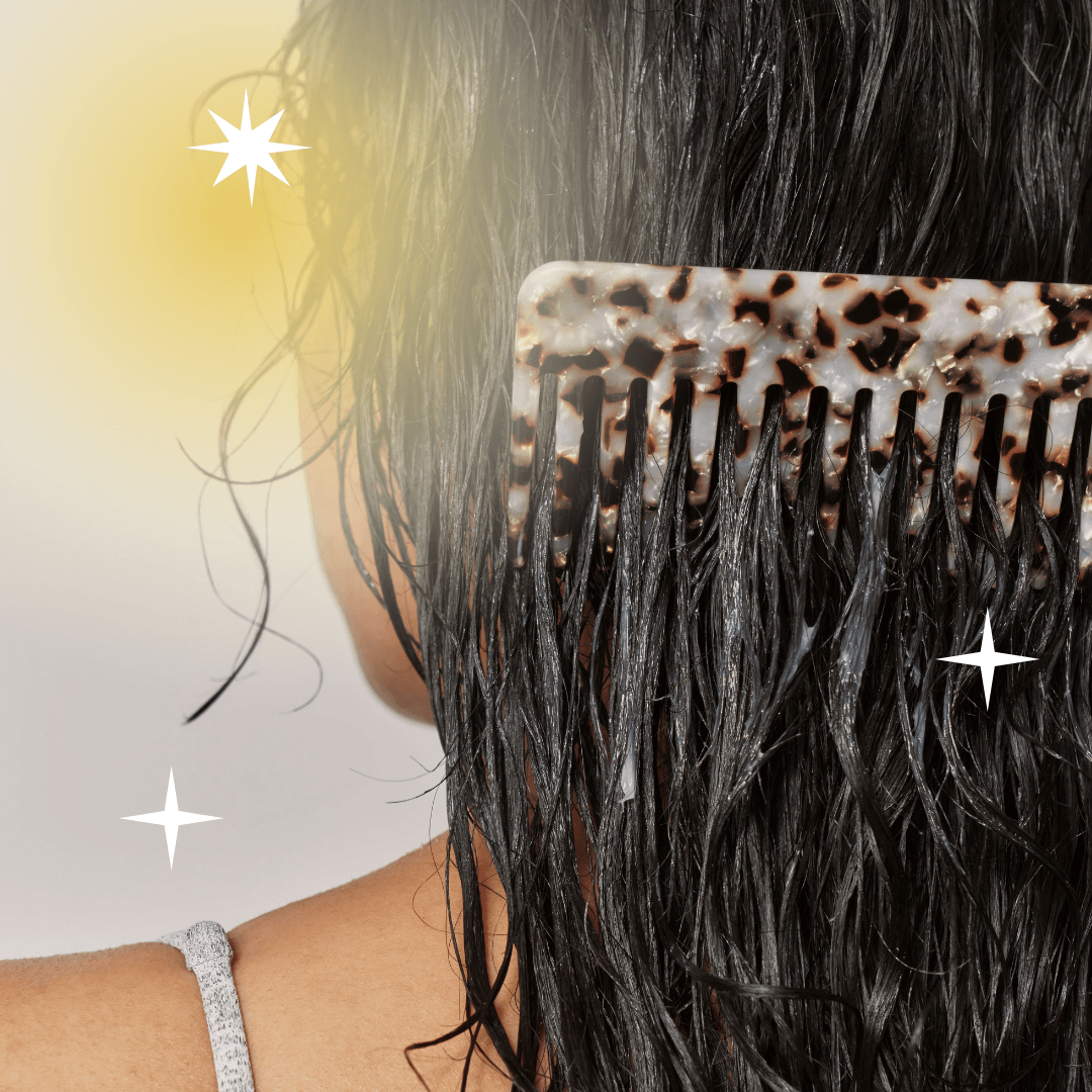 A person combing wet dark hair with a wide-tooth comb